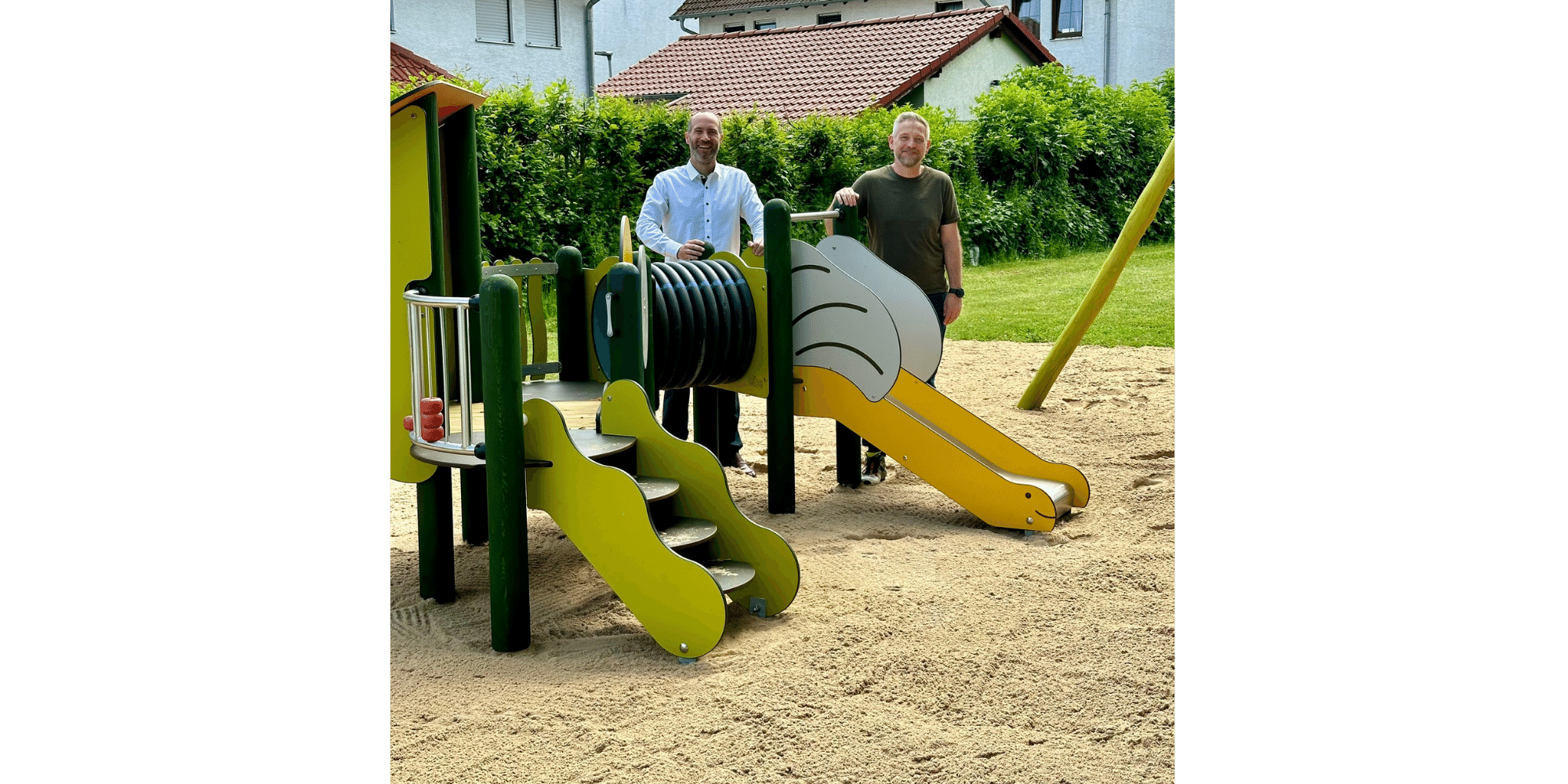 Zwei Männer stehend hinter einem Kleinkinder-Spielplatz