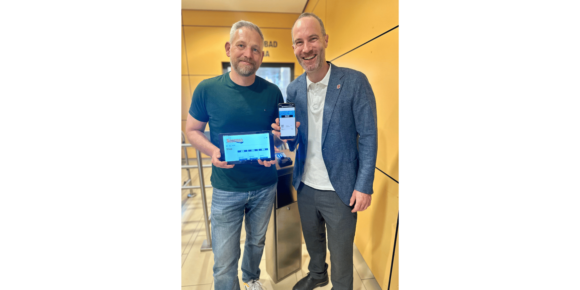 Zwei Männer stehend mit einem Tablet und einem Handy in der Hand