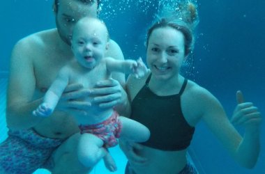 Familie taucht unter Wasser mit Baby
